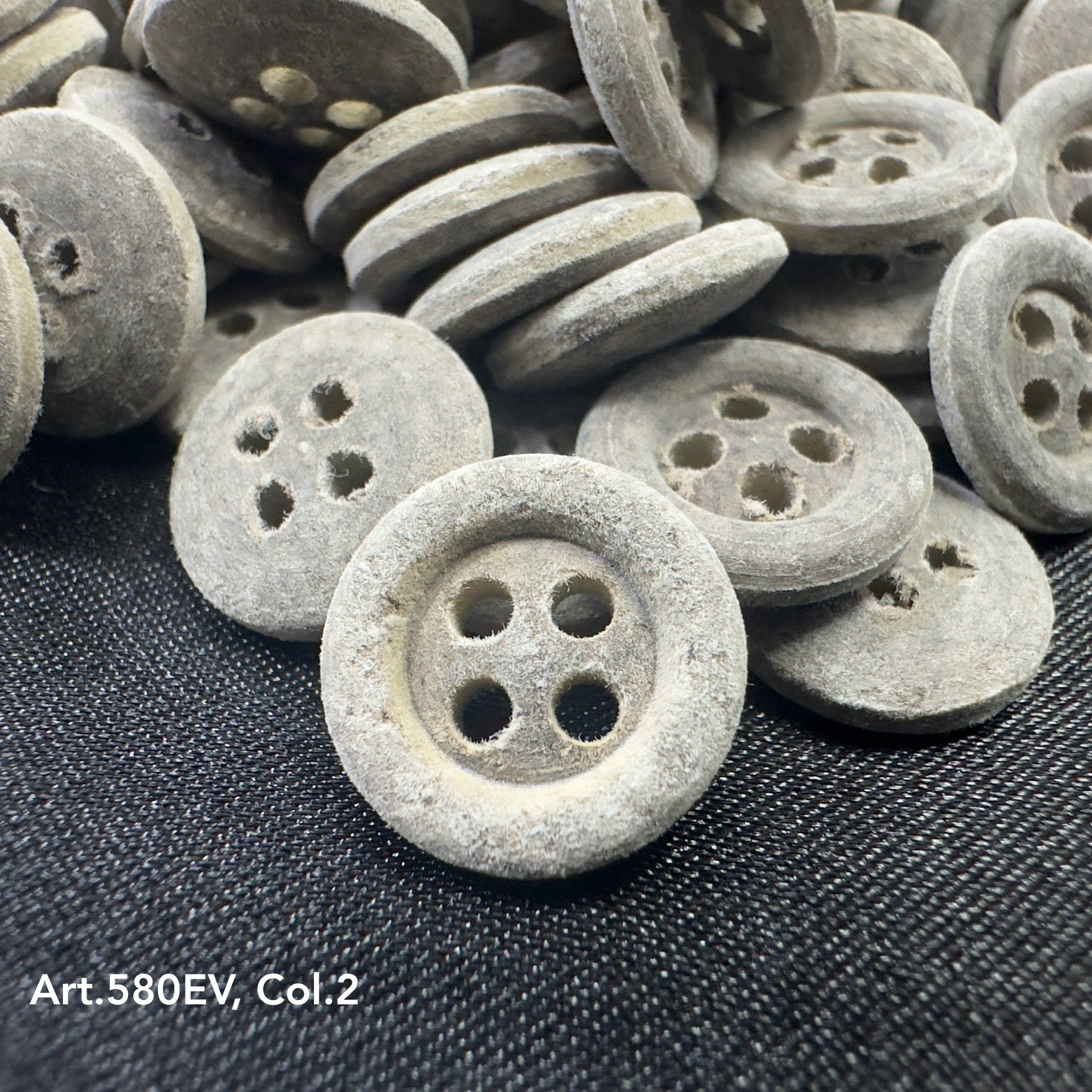 Close-up of eco-friendly velvet buttons by Buttonology Inc with a textured gray finish
