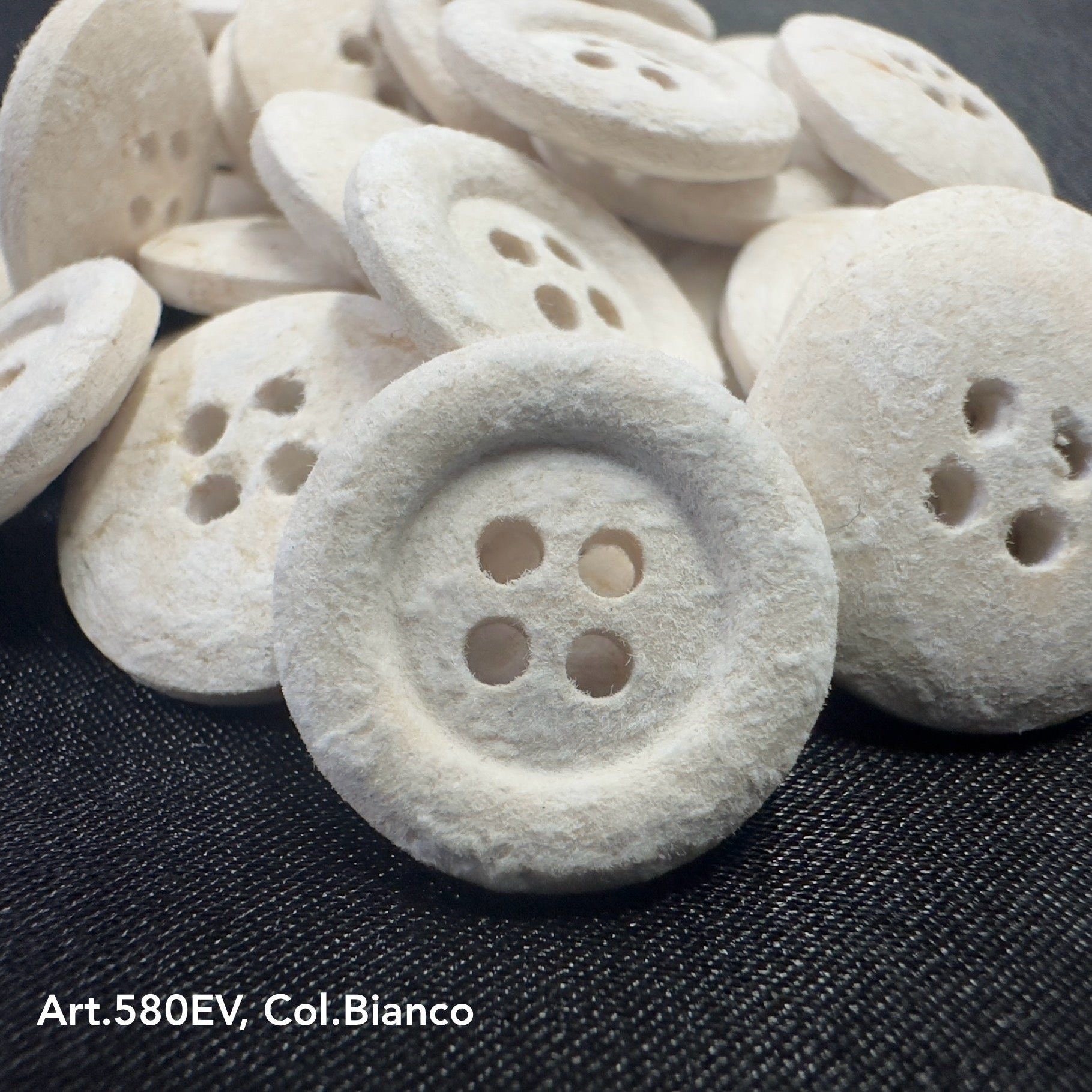 Eco-friendly velvet buttons by Buttonology Inc in white color with four holes for sewing