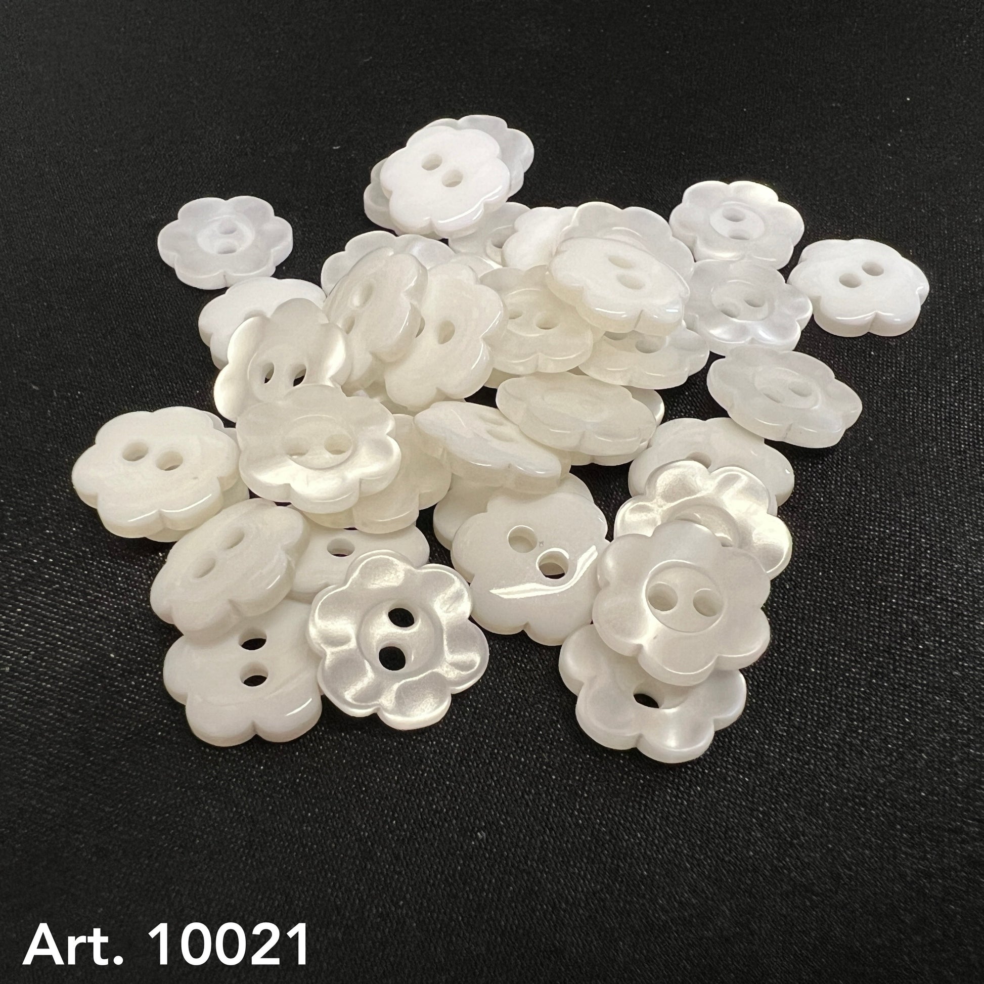 White floral garment buttons from Buttonology Inc. featuring a delicate flower shape for sewing projects