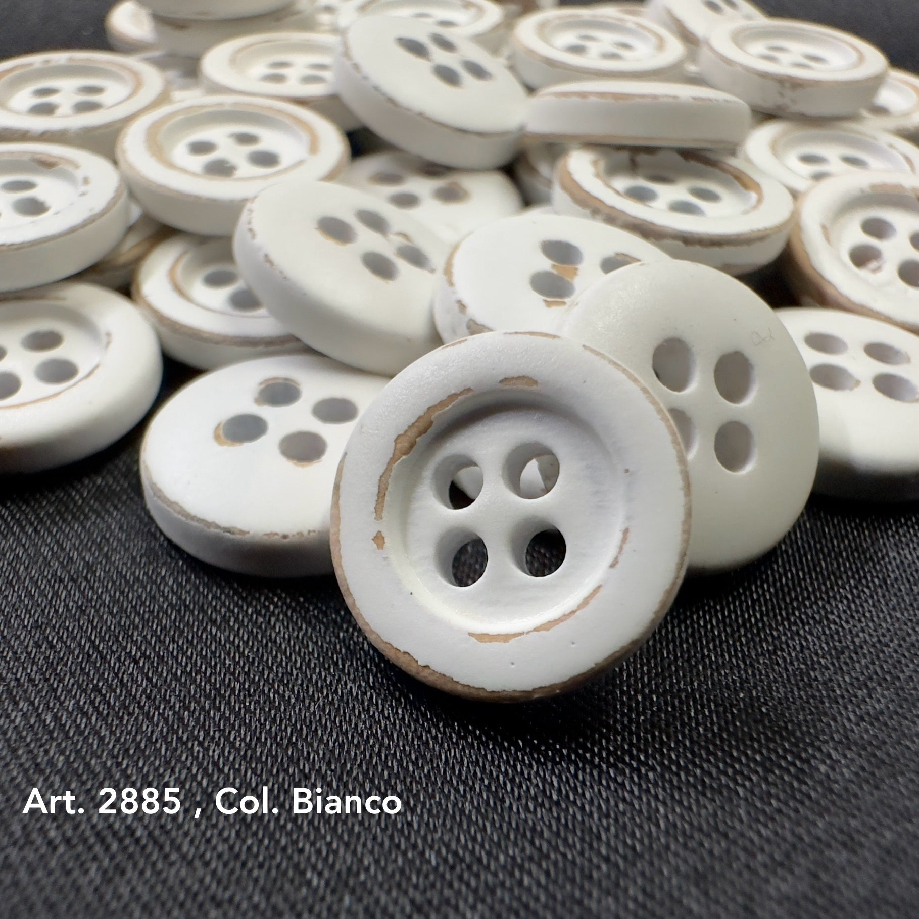 White wooden buttons for sewing with four holes and a rustic finish, perfect for crafts and garments