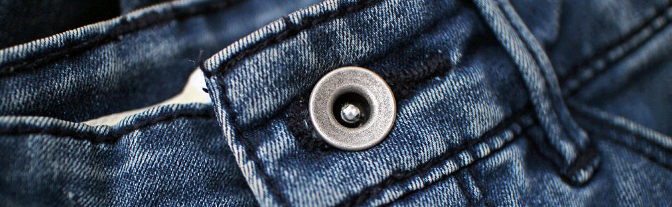 Close-up of durable metal jean button on sturdy blue denim fabric to buy jean buttons online