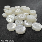 White 4 hole garment buttons from Buttonology Inc. arranged on a black surface