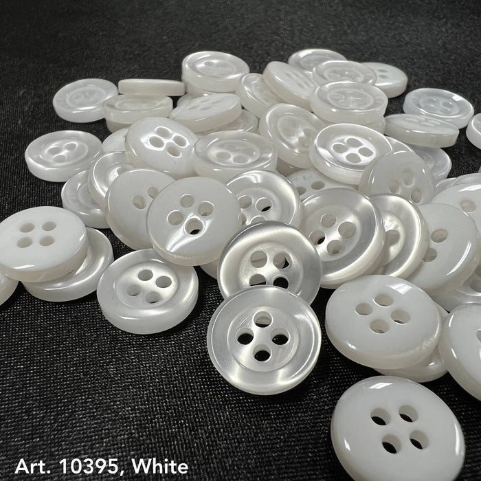 4-hole white buttons from Buttonology Inc scattered on a black fabric background