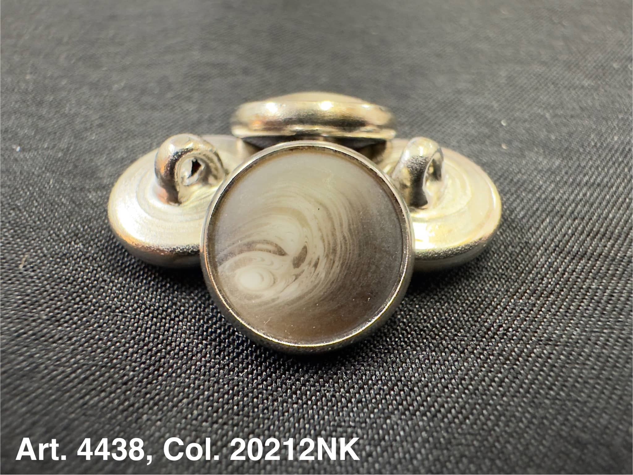 Buttonology Inc round metal button shank with marbled center on black fabric polyester garment shank