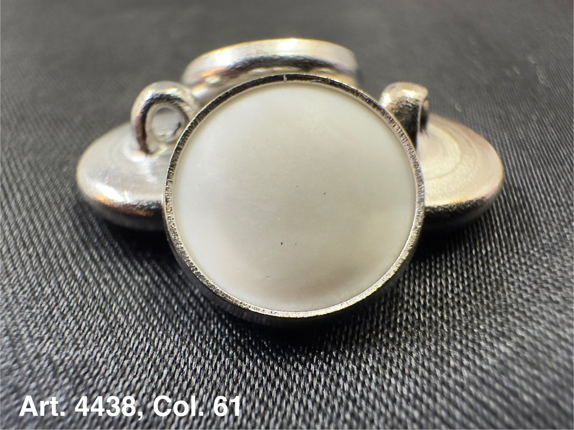 Buttonology Inc silver rim button shank with white center close up polyester garment shank for tailored coats