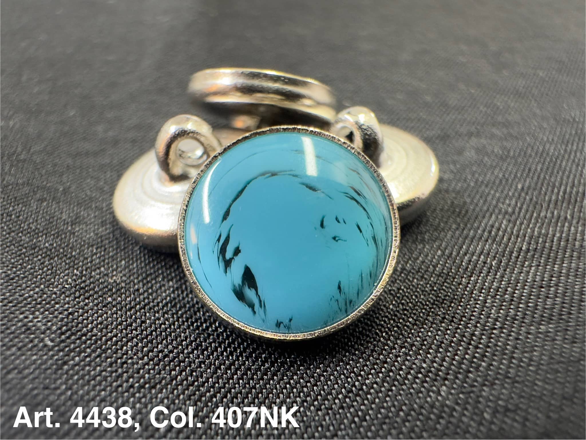 Buttonology Inc polyester garment shank turquoise cabochon set in silver metal decorative shank button on black fabric