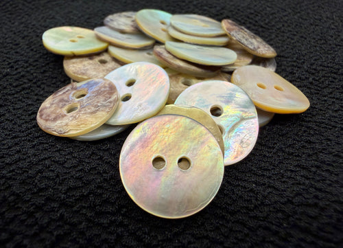Collection of round, multicolored buttons on a dark textured surface