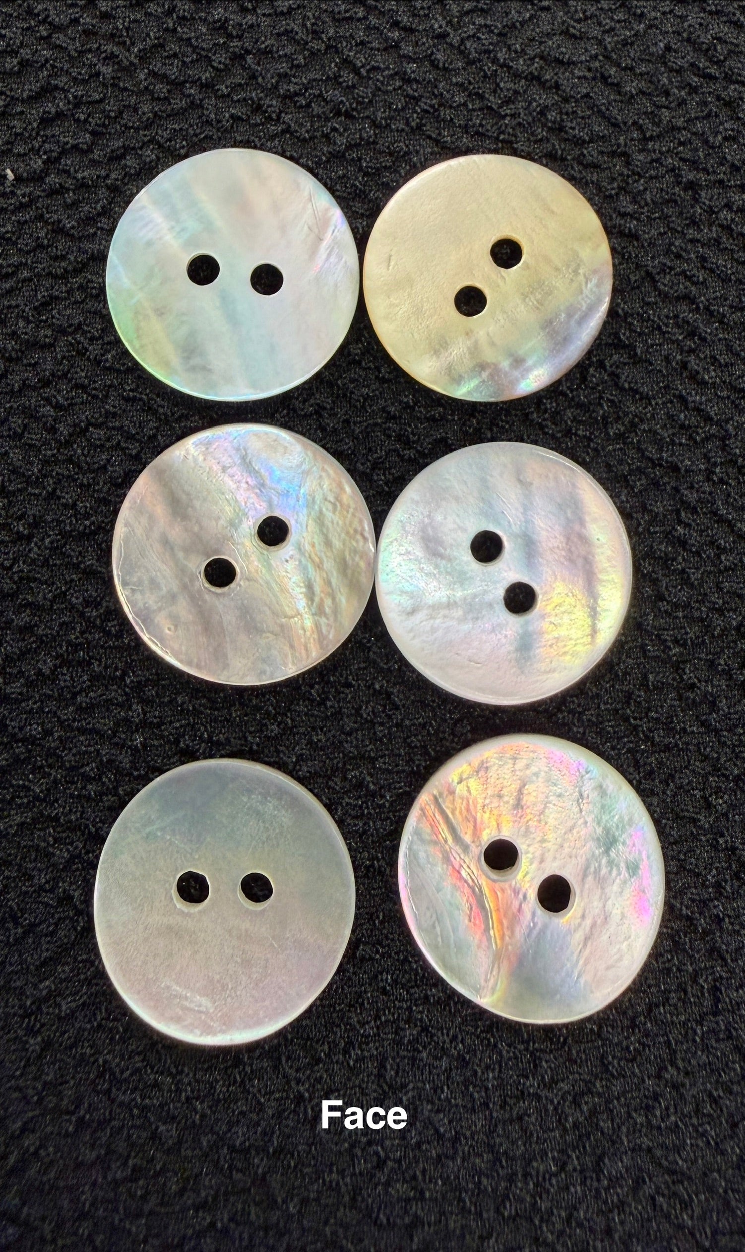 Set of six round, multicolored buttons on a black background