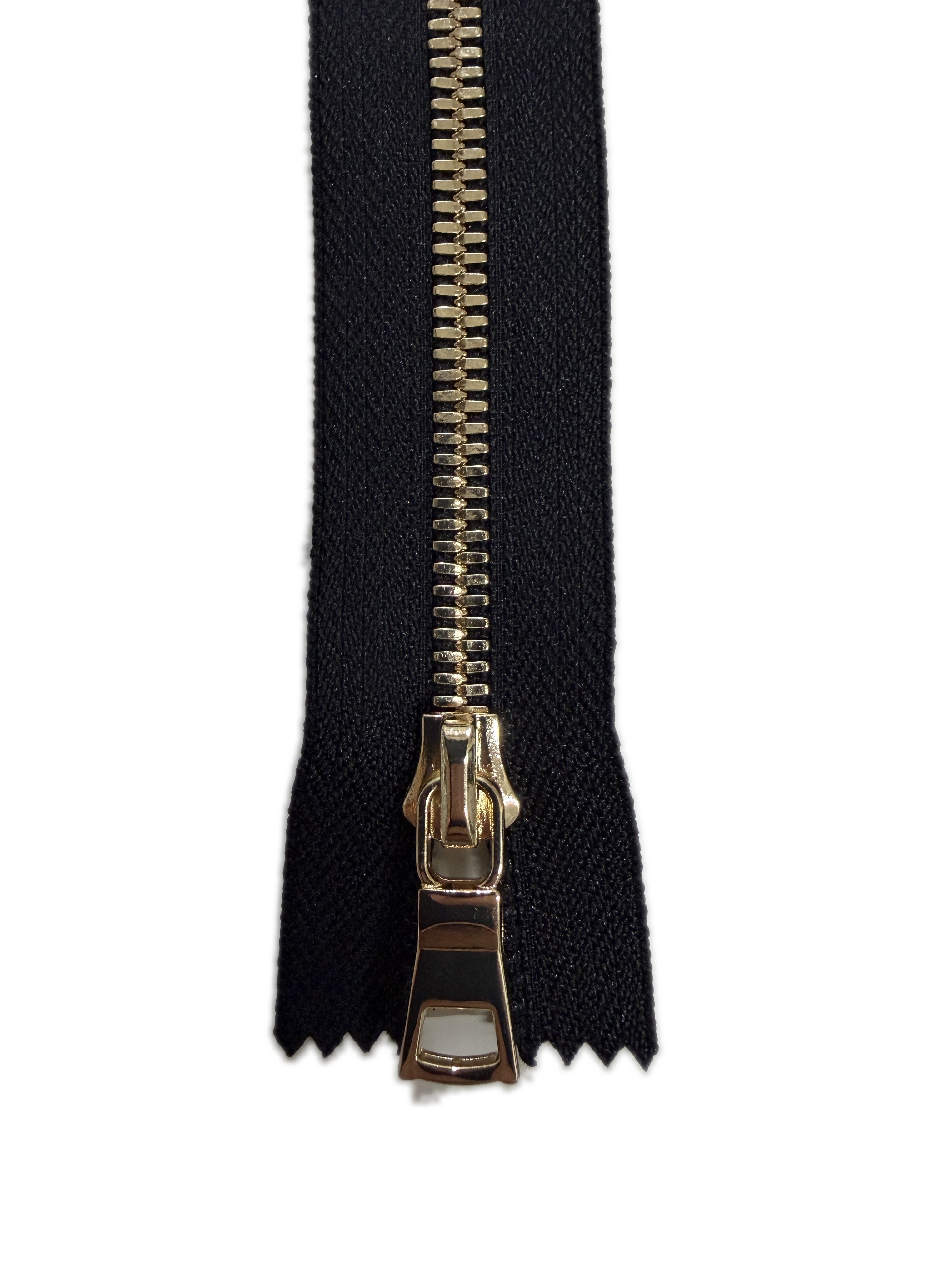 Black fabric with a gold zipper on a white background
