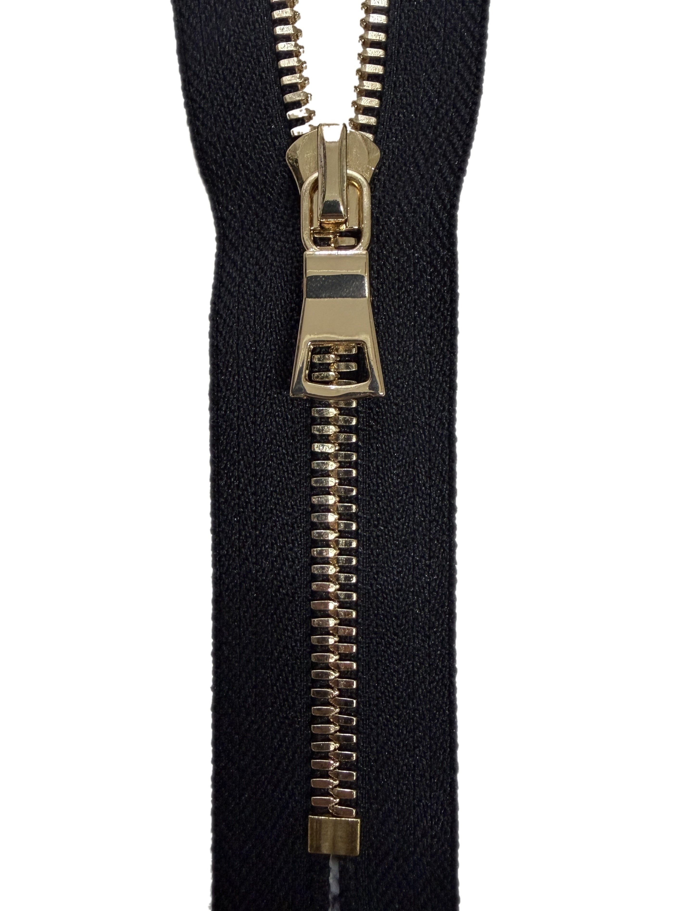 Black zipper with gold metal teeth on a white background