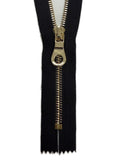 Black zipper with gold pull on a white background