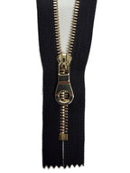 Black zipper with gold pull on a white background