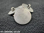 Two metallic round pendants on a textured dark surface