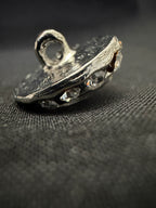 Close-up of a metal gear or sprocket on a textured black background