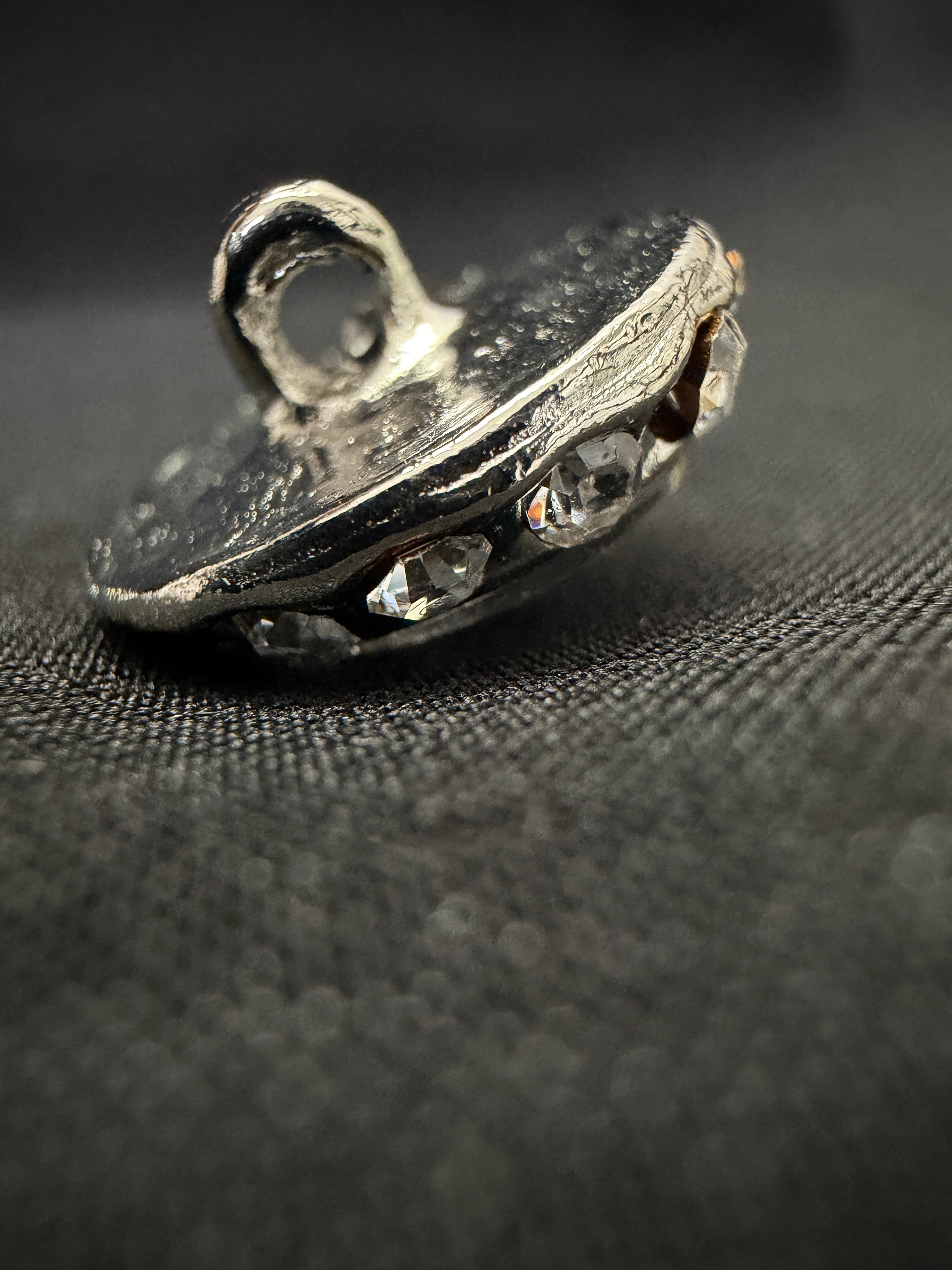 Close-up of a metal gear or sprocket on a textured black background
