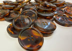Collection of tortoise buttons on a white surface