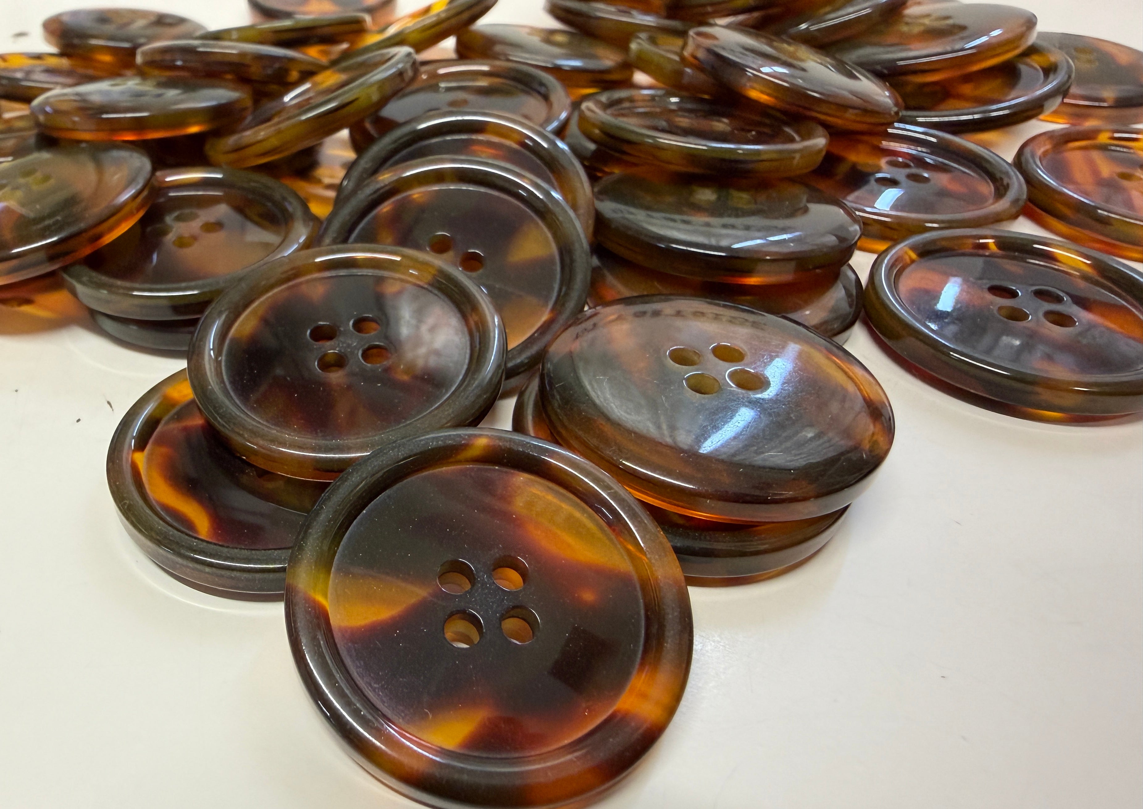 Collection of tortoise buttons on a white surface