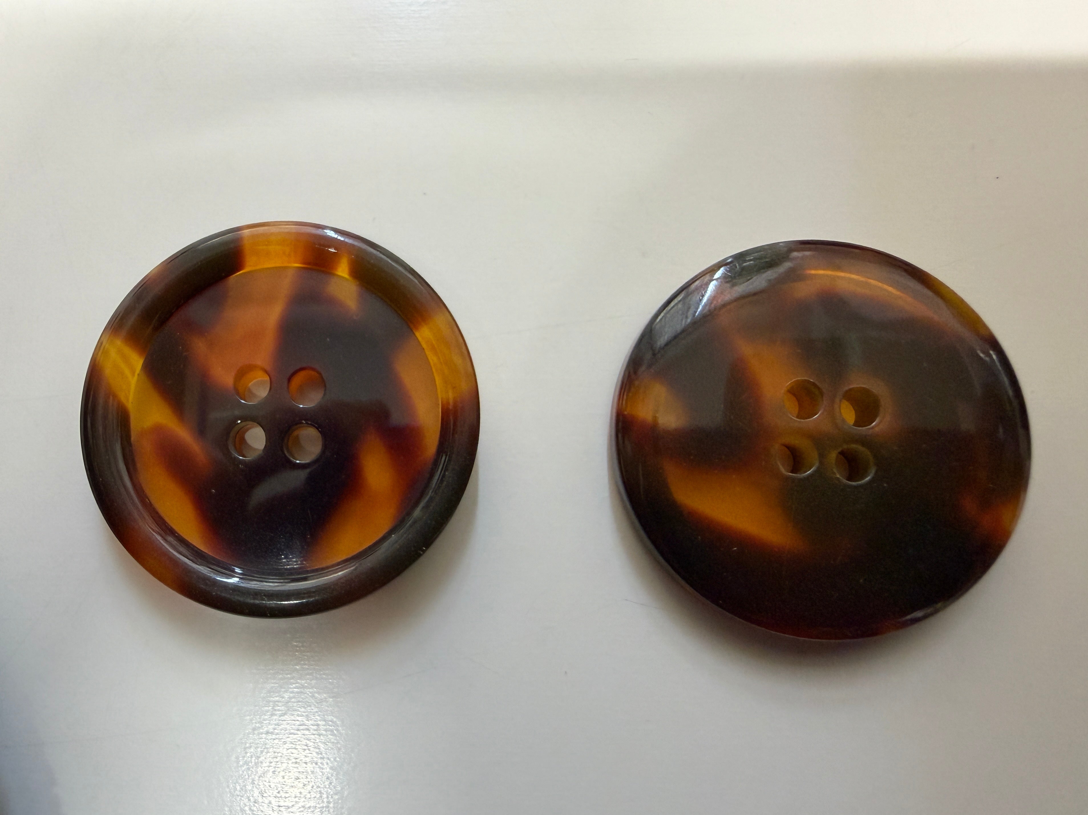 Two tortoiseshell buttons on a white background