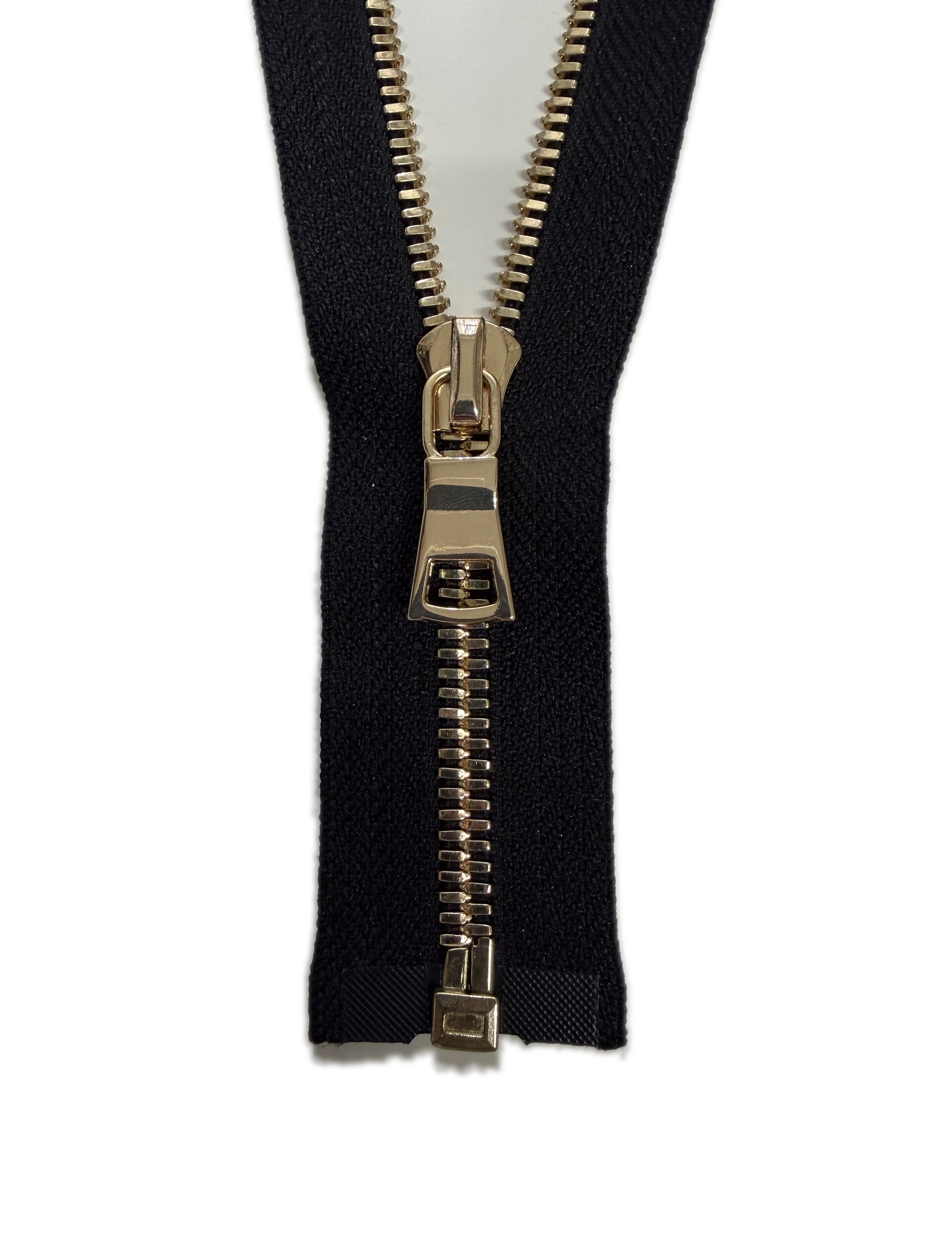 Black fabric with a gold zipper on a white background