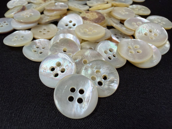 Collection of white buttons with four holes on a black background