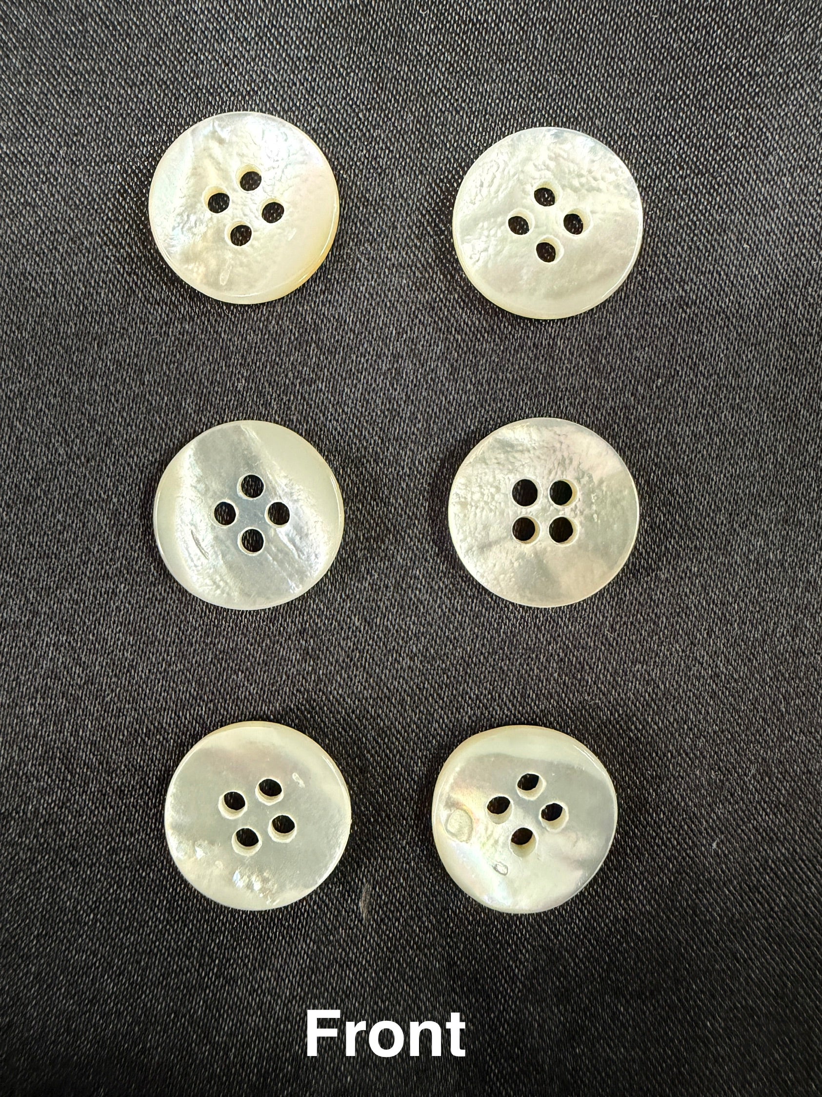 Six white buttons with four holes on a black background, labeled 'Front'.