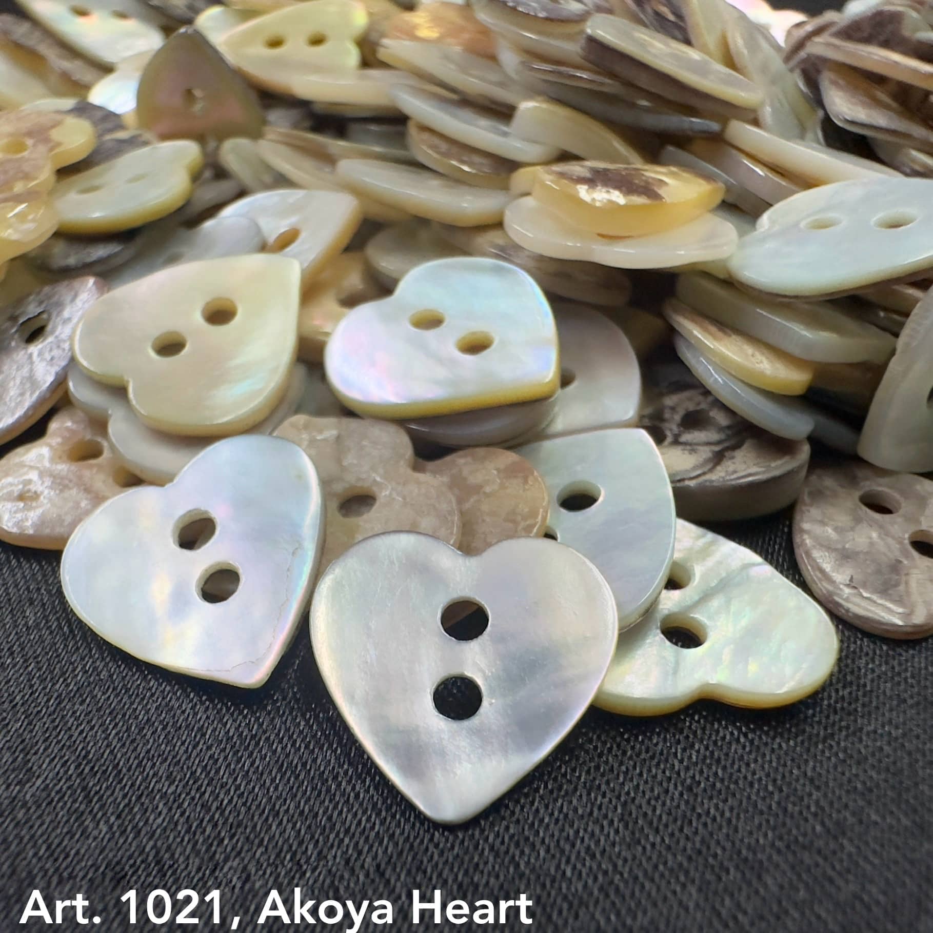 Akoya heart buttons by Buttonology Inc with iridescent finish and two holes for sewing