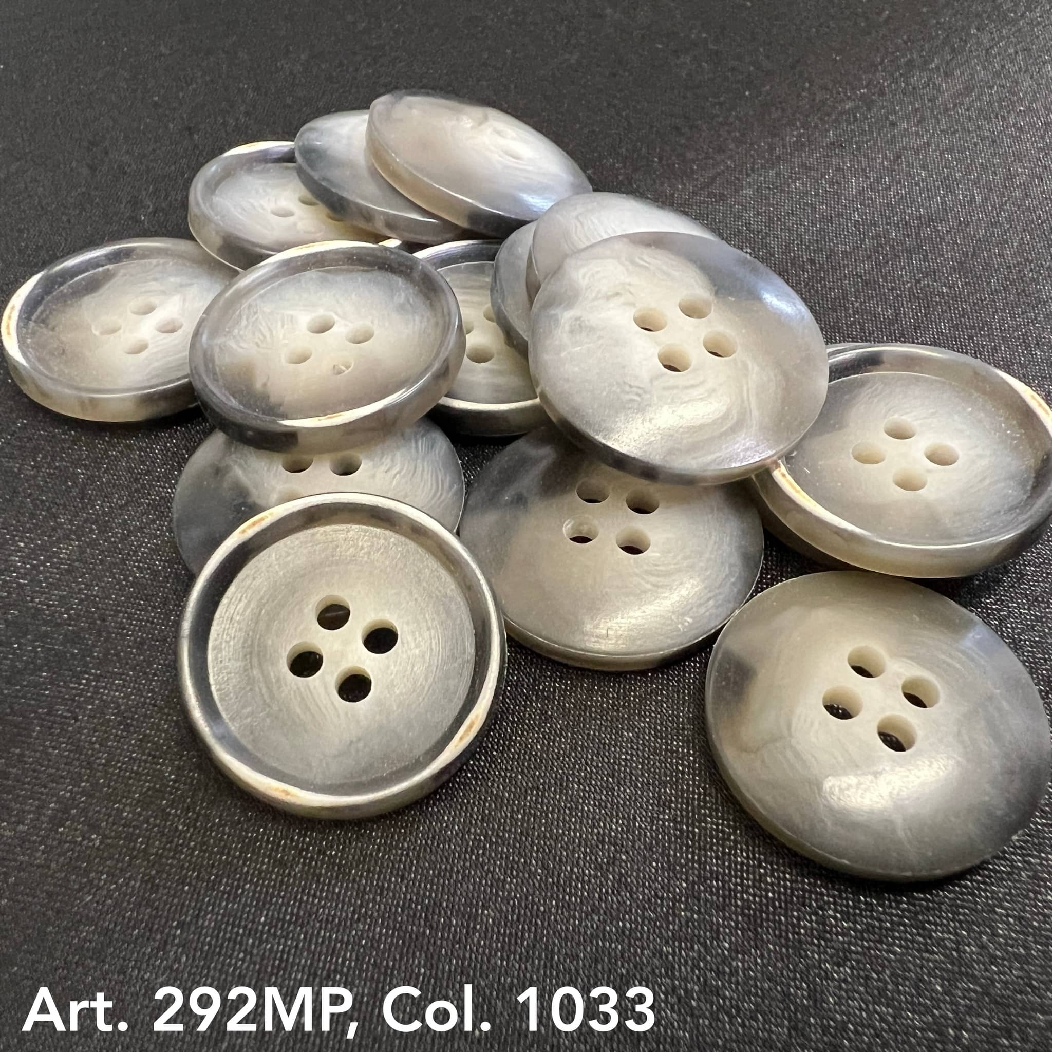 Buttonology Inc gray marbled four hole round shirt buttons for sewing on dark fabric background