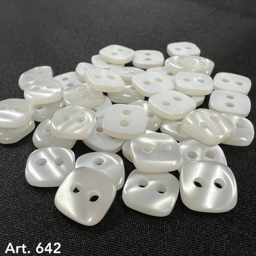 Art 642 high-quality buttons in white pearl finish by Buttonology Inc scattered on black fabric