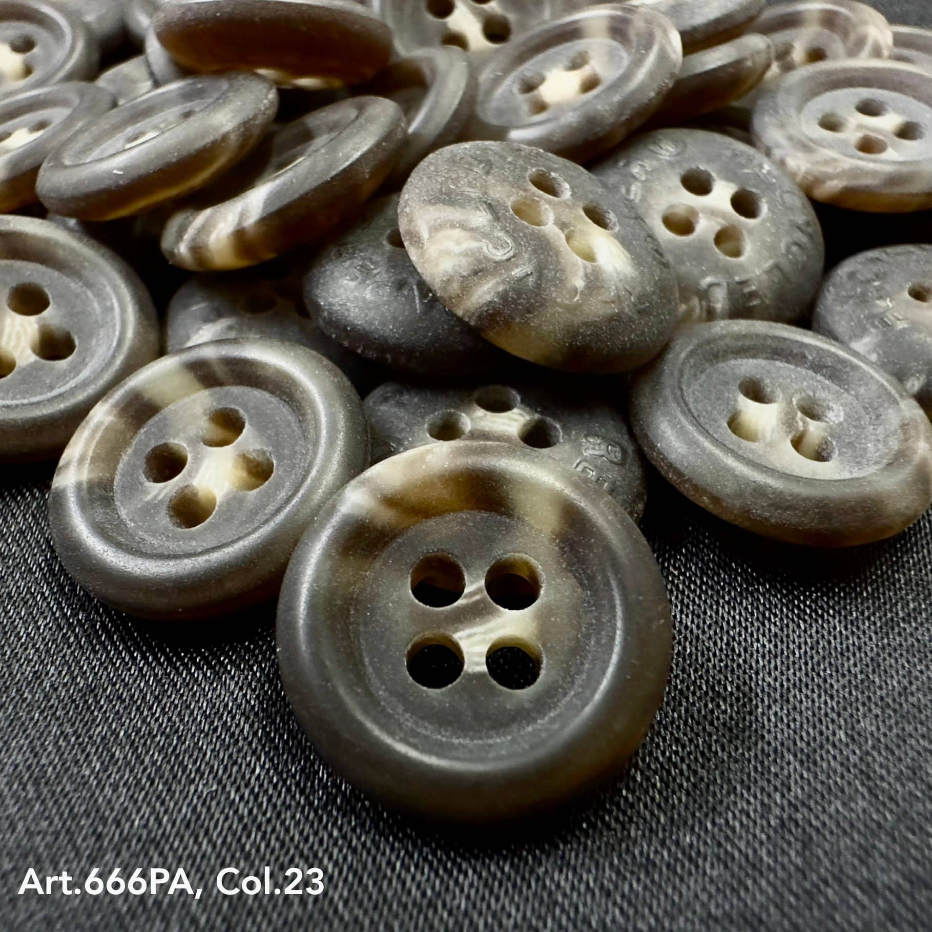 Close-up of Buttonology Inc recycled paper buttons in gray and brown tones with four holes