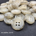 Recycled paper buttons from Buttonology Inc in round shape with four holes, cream color on dark fabric background