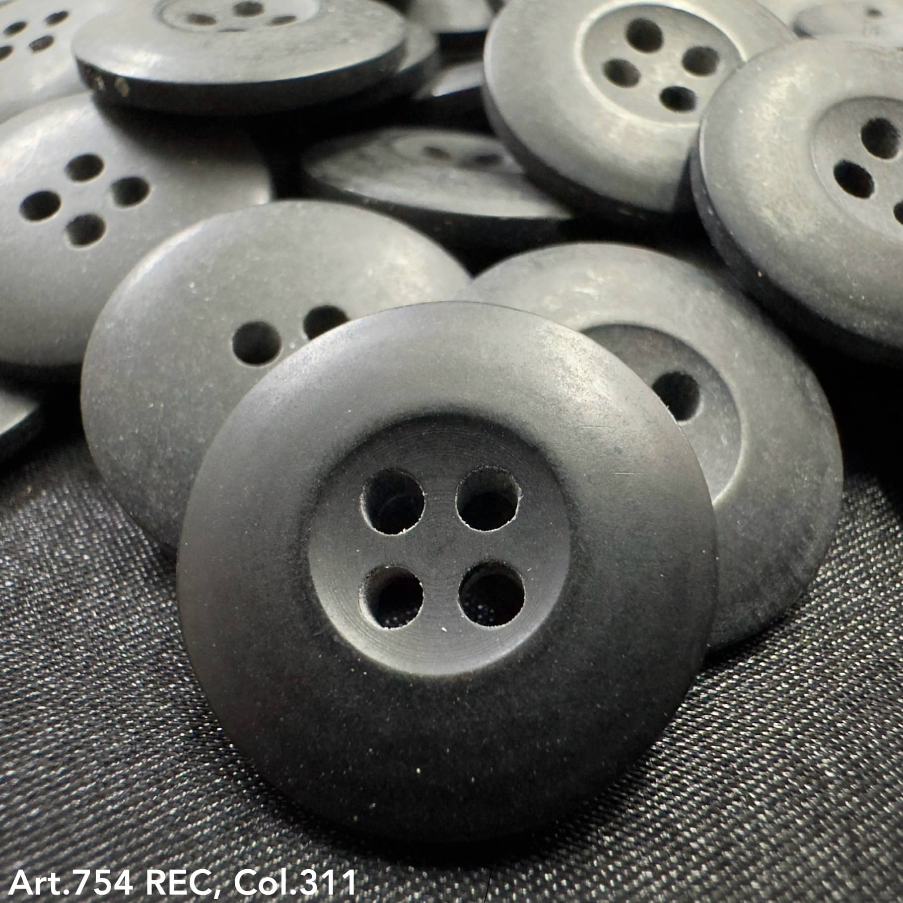 Black plastic buttons with four holes showcasing custom button designs by Buttonology Inc