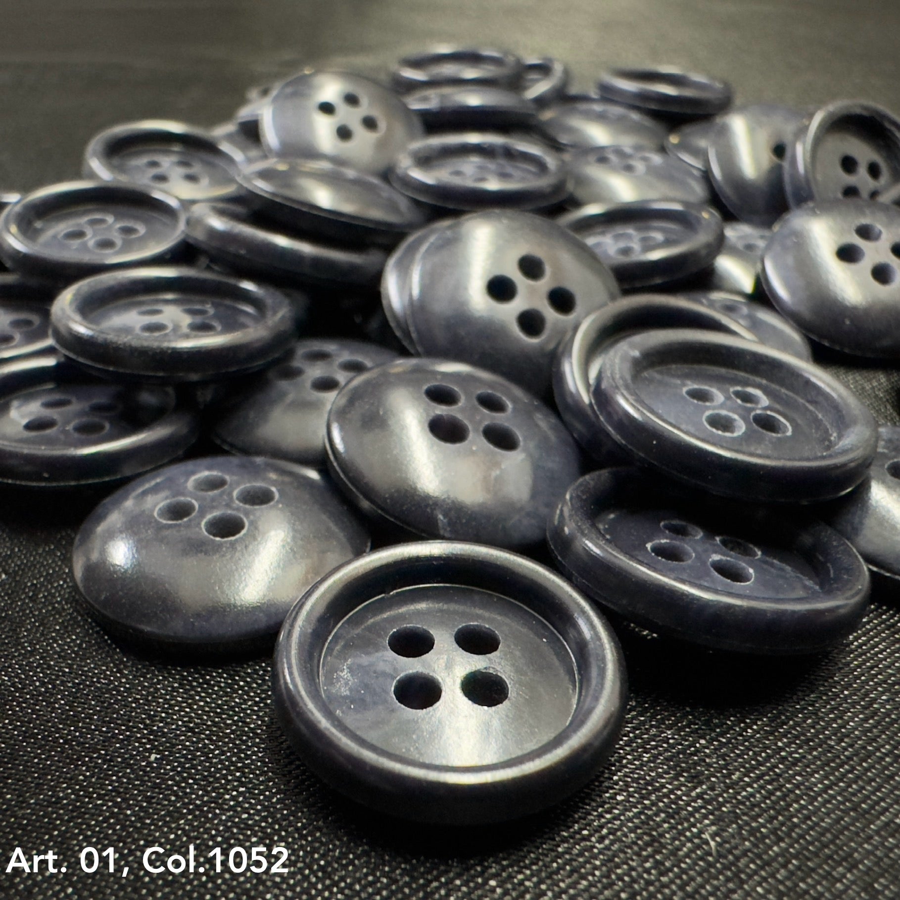 Pile of dark gray glossy four hole round buttons for shirts by Buttonology Inc premium shirt buttons for sewing