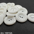 White glossy two hole round buttons on dark fabric by Buttonology Inc white garment buttons for sewing projects