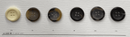 Variety of black 4-hole garment buttons displayed on a white background for sewing projects