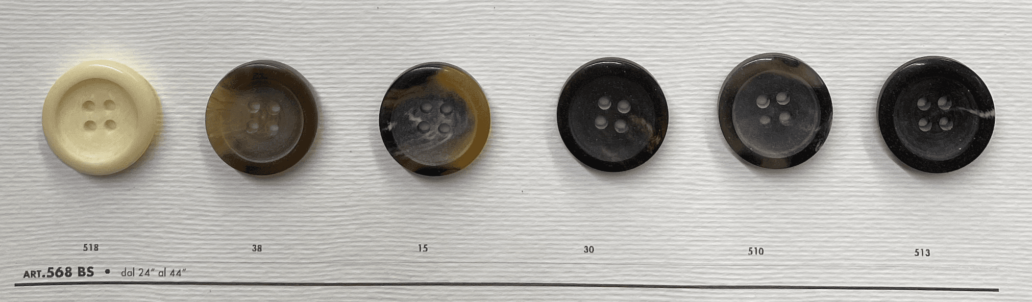Variety of black 4-hole garment buttons displayed on a white background for sewing projects