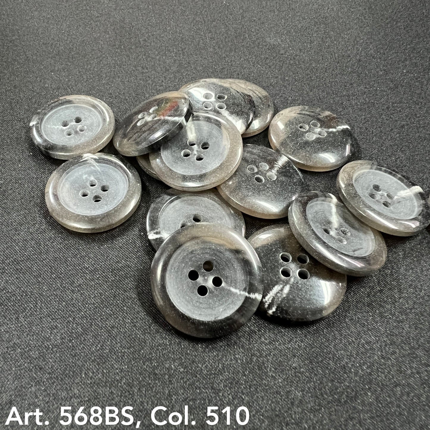 Set of black 4-hole garment buttons with a polished finish and unique marble patterns
