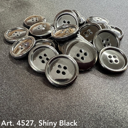 Black four hole buttons for sewing arranged on a dark surface, showcasing their shiny finish