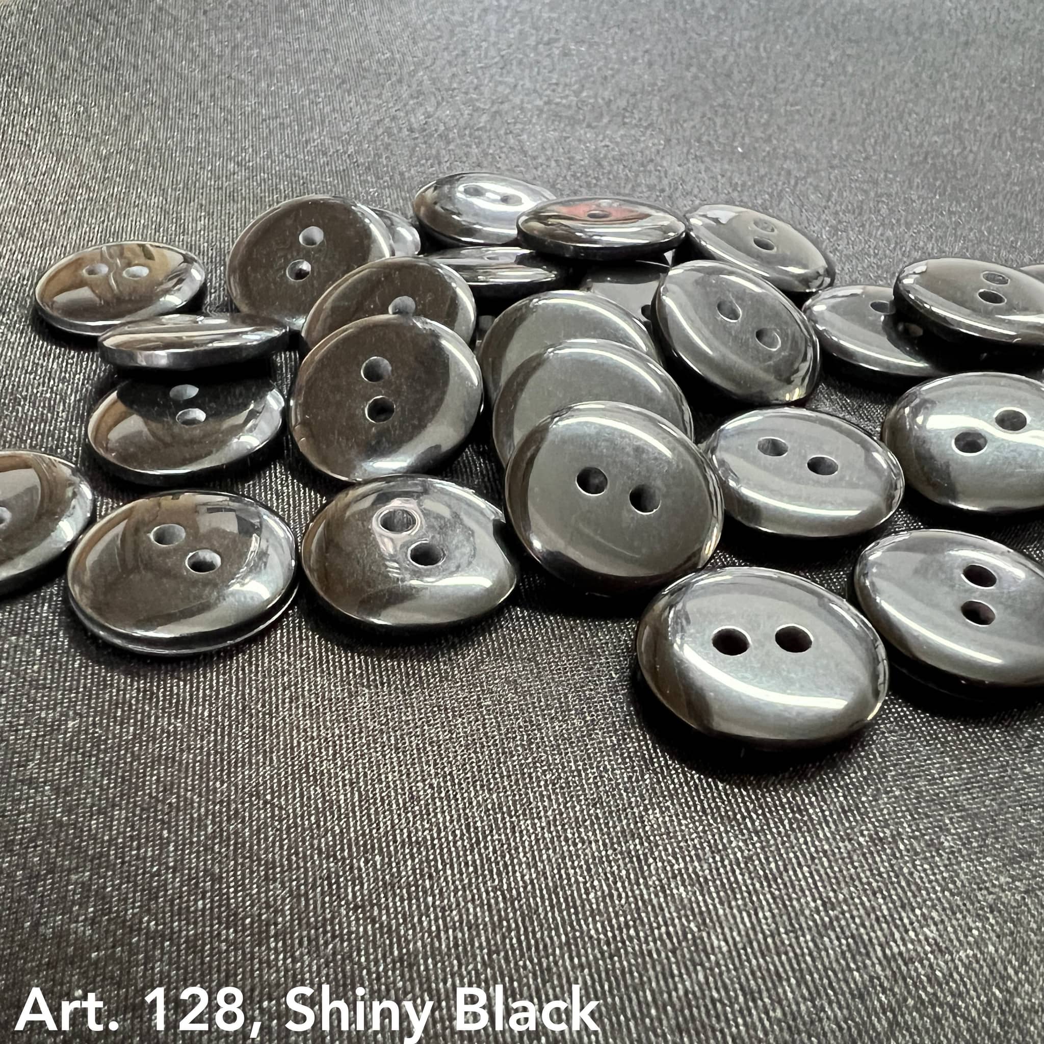 Collection of shiny black sewing buttons for clothes with two holes each, ideal for various garments