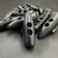 Black toggle buttons from Buttonology Inc with two holes on a black surface