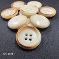 Burnt corozo button for shirts by Buttonology Inc with four holes on dark fabric background