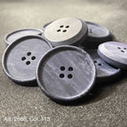 Buttonology Inc navy four hole matte sew on buttons piled on fabric for garment and craft use wholesale button supplies online