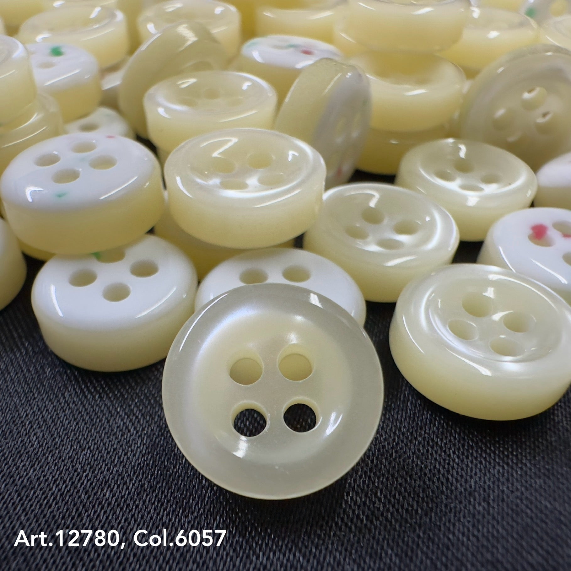 Close-up of cream and white buttons on black fabric from Buttonology quality button supply