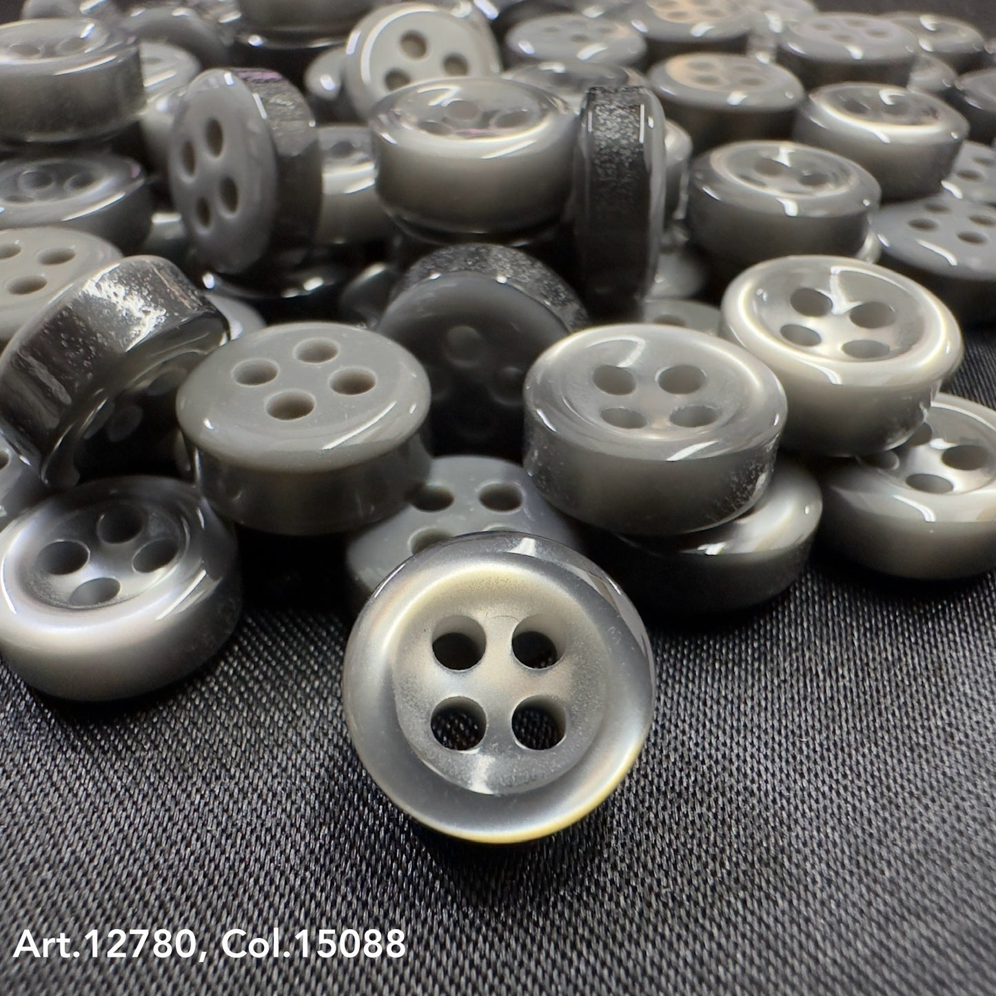 Close-up of Buttonology quality button supply showing gray four-hole buttons on black fabric