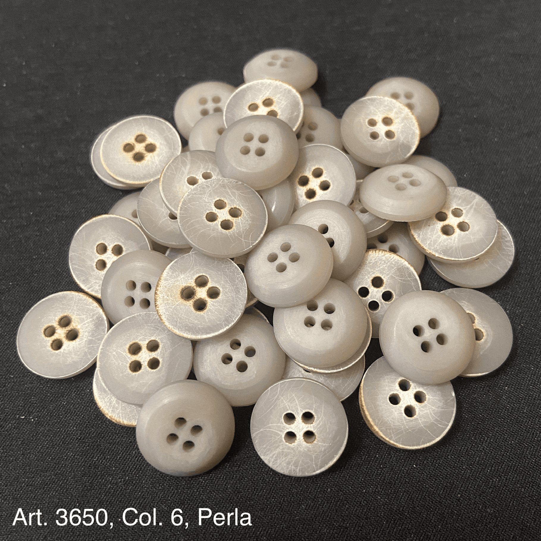 Elegant gray buttons for shirts and blouses with a shiny finish and four holes for easy sewing
