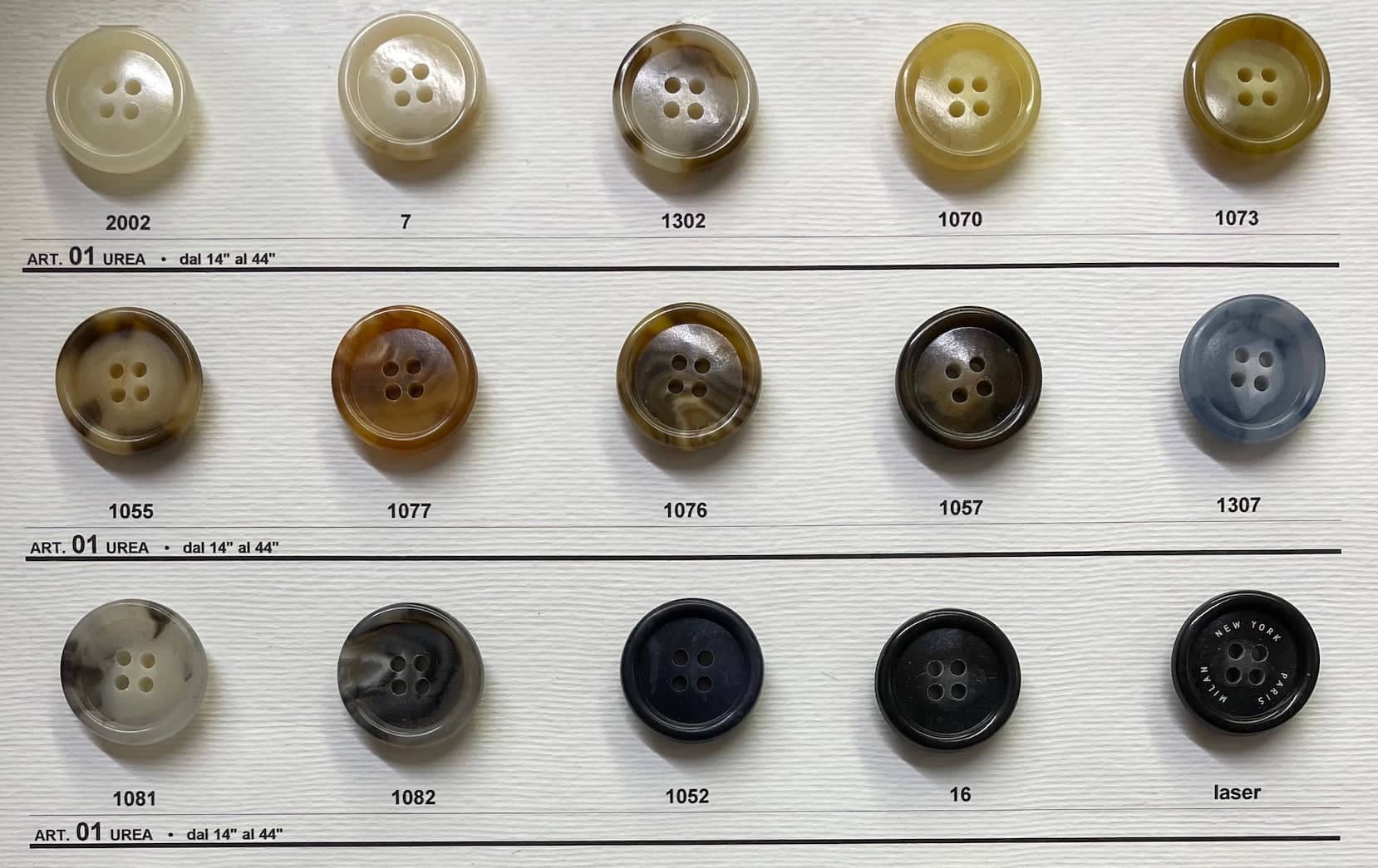 Variety of coat buttons for sewing displayed on a swatch board from Buttonology Inc.