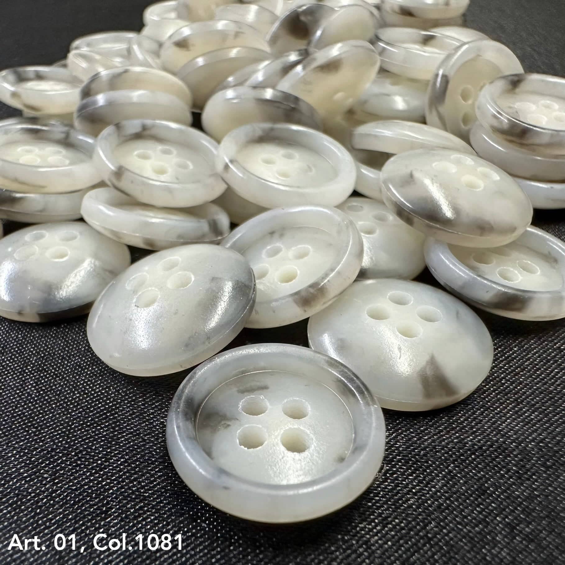 Assorted coat buttons for sewing in a glossy white finish with four holes for easy attachment
