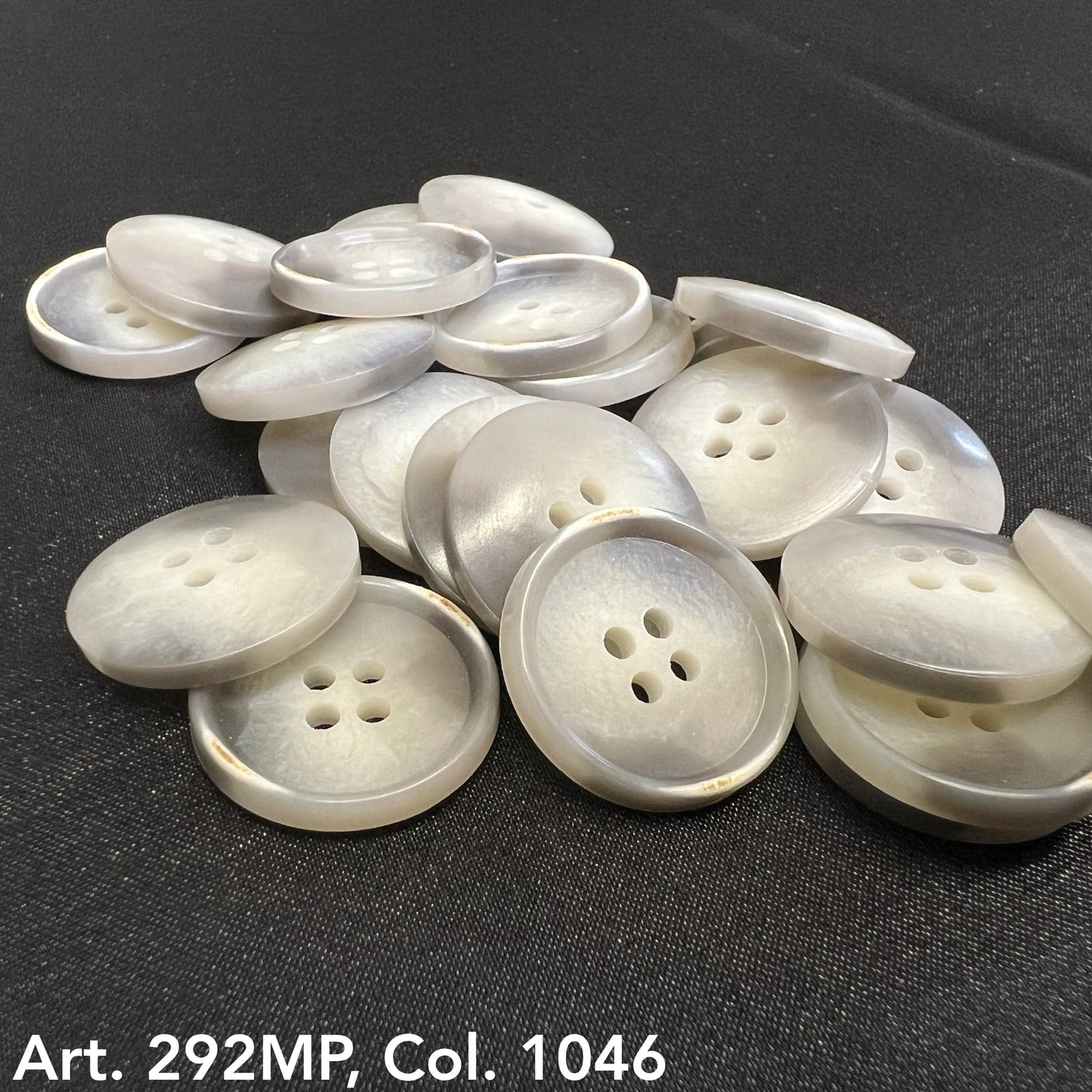 Set of coat sizing buttons in a pearlescent finish with four holes for easy sewing and secure attachment