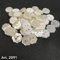 Buttonology Inc custom flower buttons in pearly white with two holes laid on black fabric background