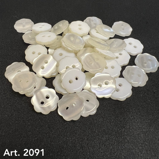 Buttonology Inc custom flower buttons in pearly white with two holes laid on black fabric background