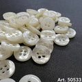 Buttonology Inc double stitching button collection in translucent white scattered on black fabric